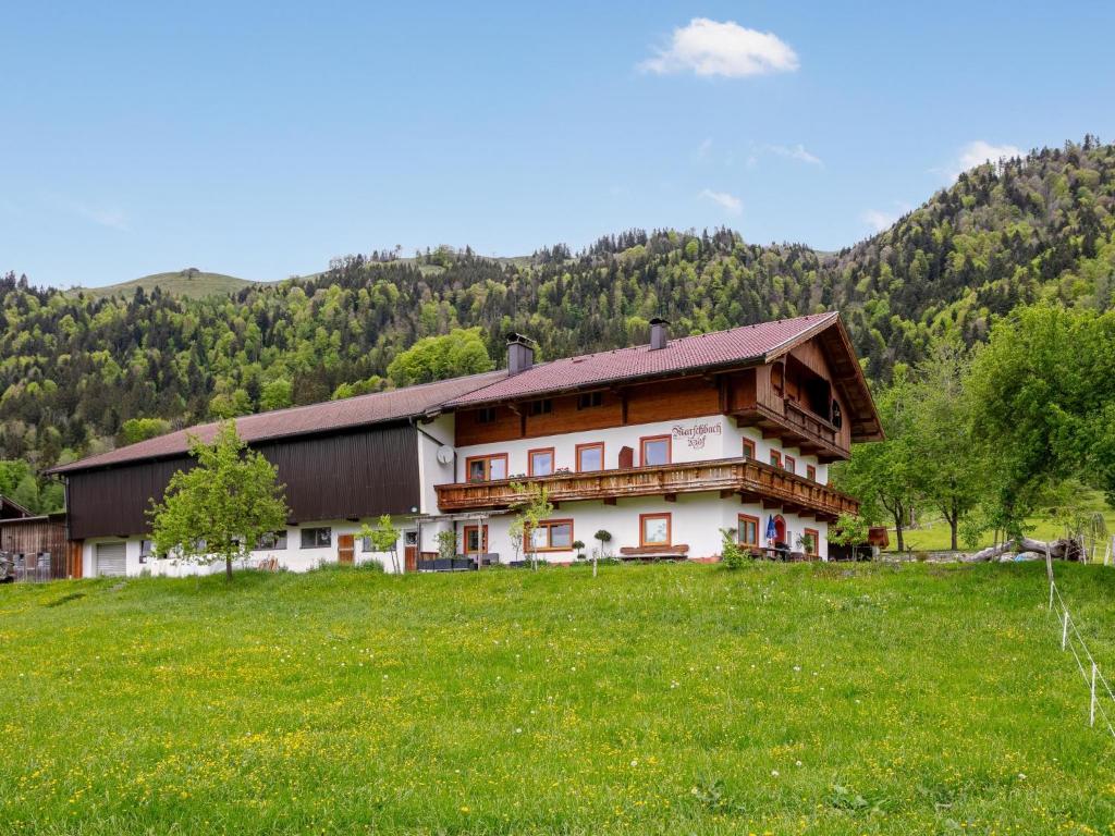 a large house in a field with a grass field at Panorama Suite am Marschbachhof in Walchsee