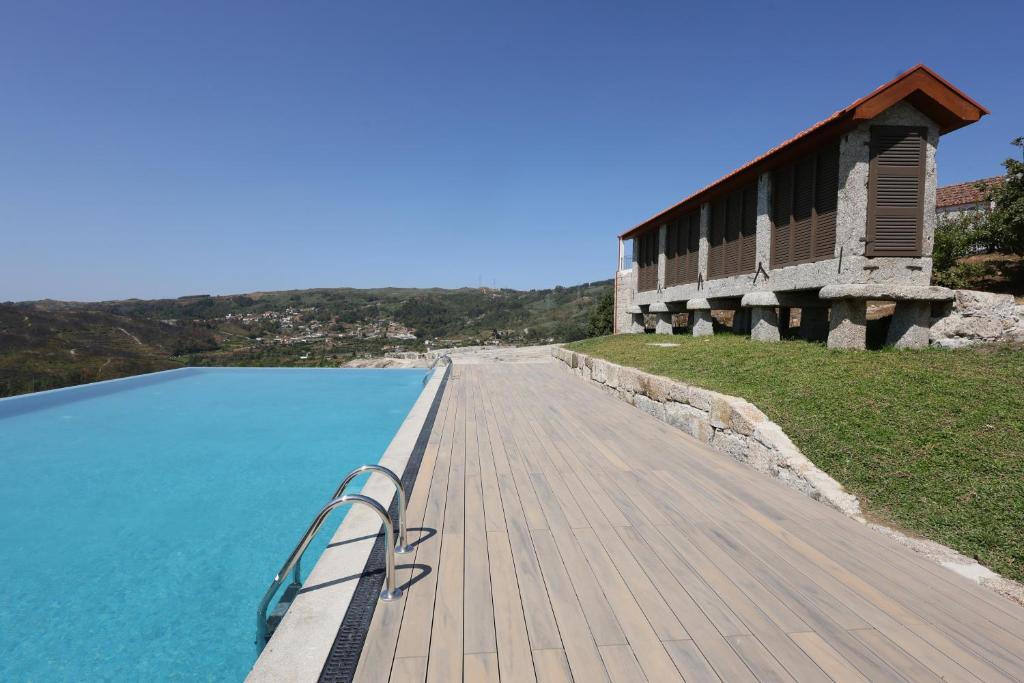 a wooden walkway next to a body of water at Quinta do Giz in Baião