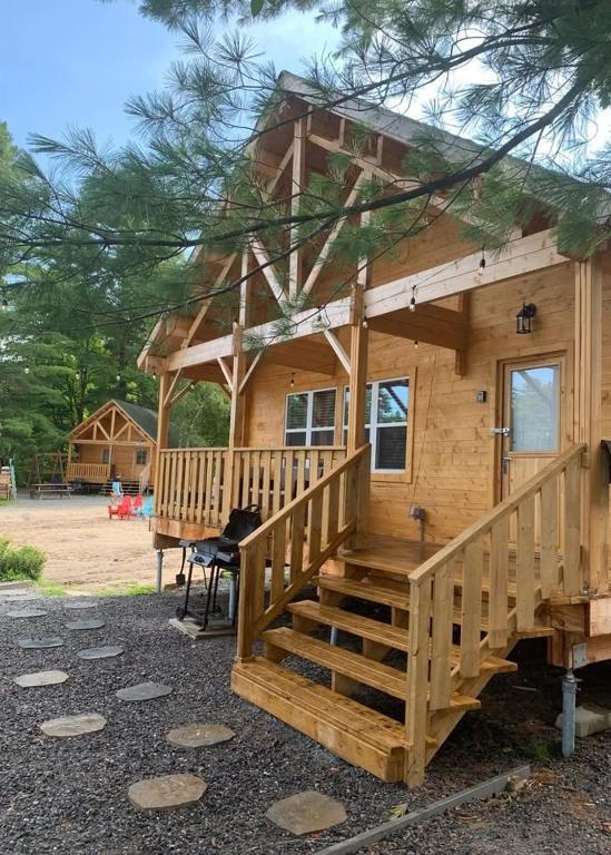 a large wooden cabin with a large wooden porch at Horseshoe Lake Beachside Cottage in Parry Sound