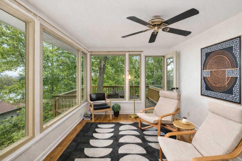 a living room with a ceiling fan and windows at Private Riverside Retreat in Appleton