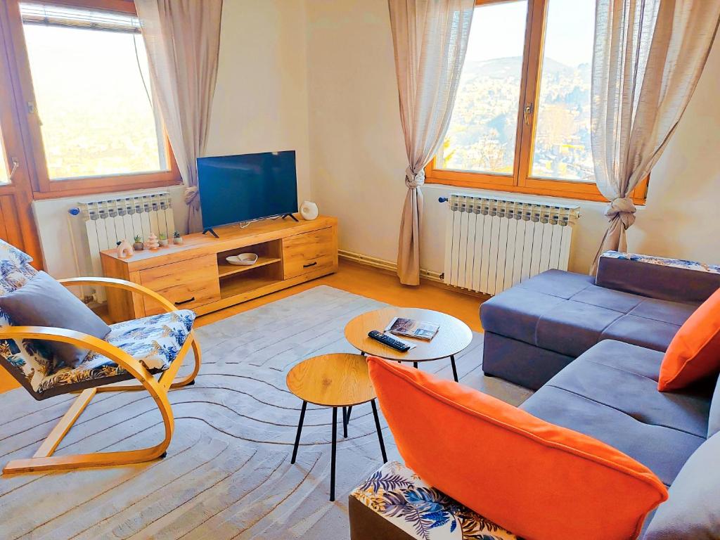 a living room with a blue couch and a tv at Panorama Sky Apartment -11 min by walk to Old Town - Free Parking in Sarajevo