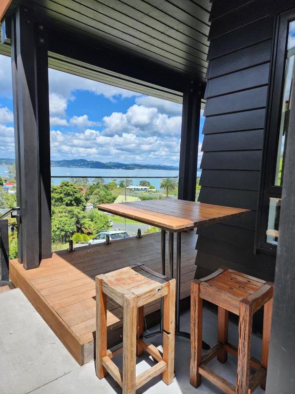 a table and two stools on a balcony with a view at Studio with amazing views in Russell