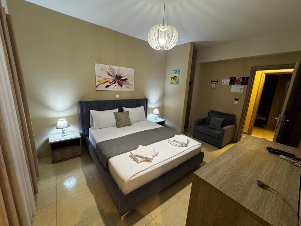 sypialnia z dużym łóżkiem i krzesłem w obiekcie Hotel Driloni w mieście Ksamil