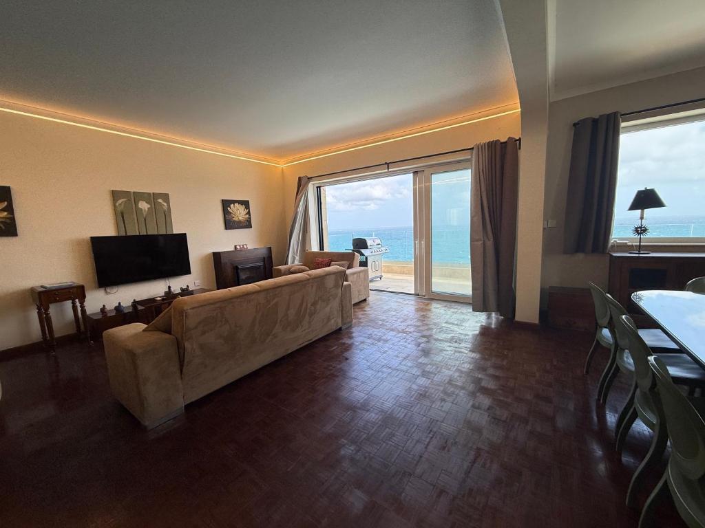 a living room with a couch and a television at Panoramic XL Penthouse Sliema Seafront in Sliema