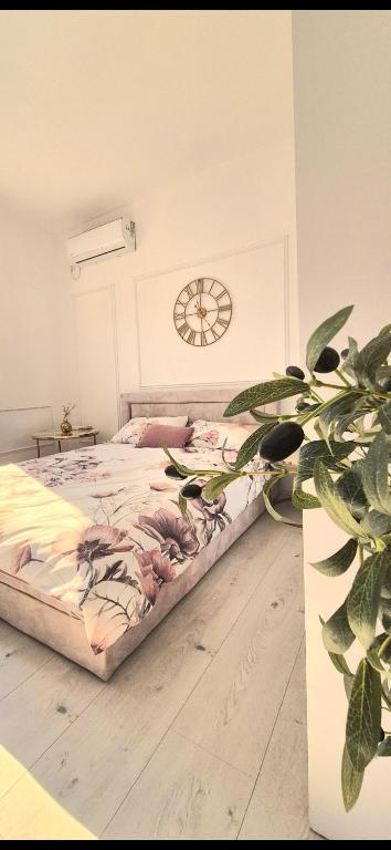 a bedroom with a bed with a clock on the wall at Apartmani Una Igalo in Igalo