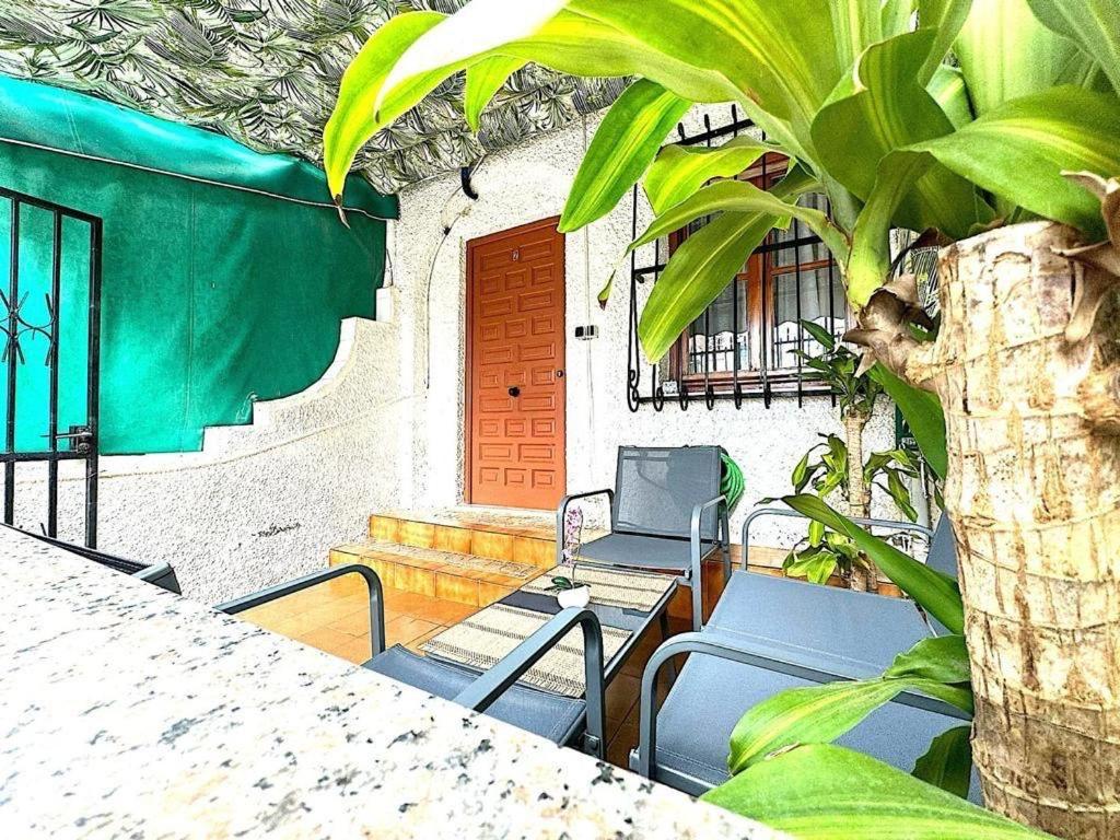 a patio with chairs and a table and a tree at Casita de Lucia in Santa Pola