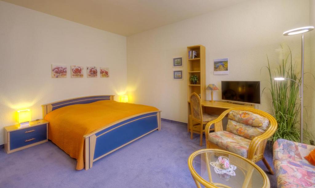 1 dormitorio con cama, mesa y sofá en Haus Sonnenruh, en Oberhof