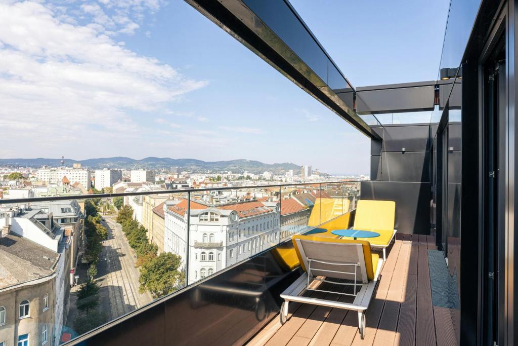 a balcony with chairs and a table on a building at The Social Hub Vienna in Vienna