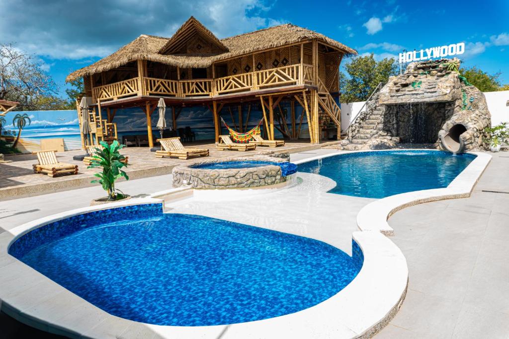 a resort with two swimming pools and a house at Estados Unidos Experience in Ríohacha
