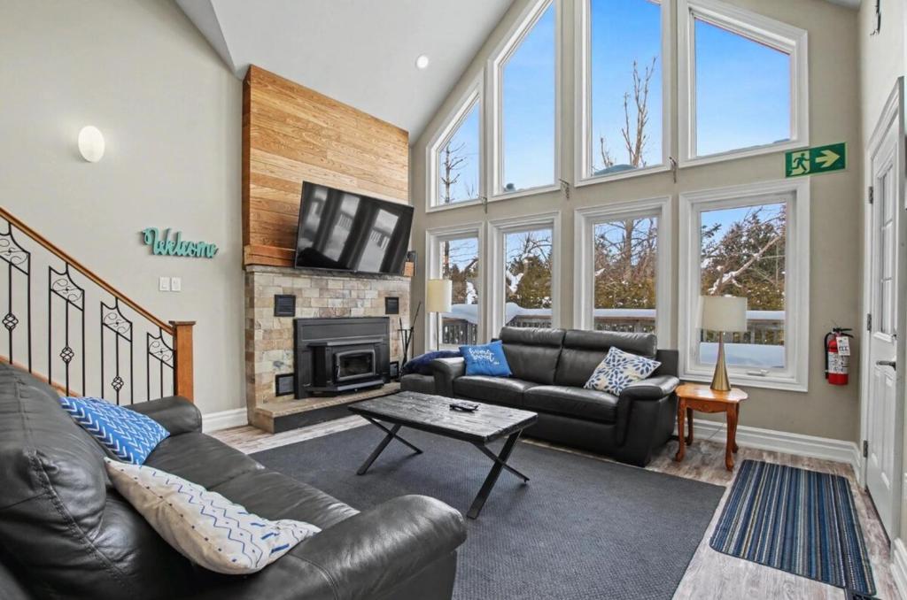 a living room with leather furniture and a fireplace at Executive-BBQ-Full-Kitchen-Washer-Dryer-Sauna-Backyard-Parking-Air-Conditioning in Blue Mountains