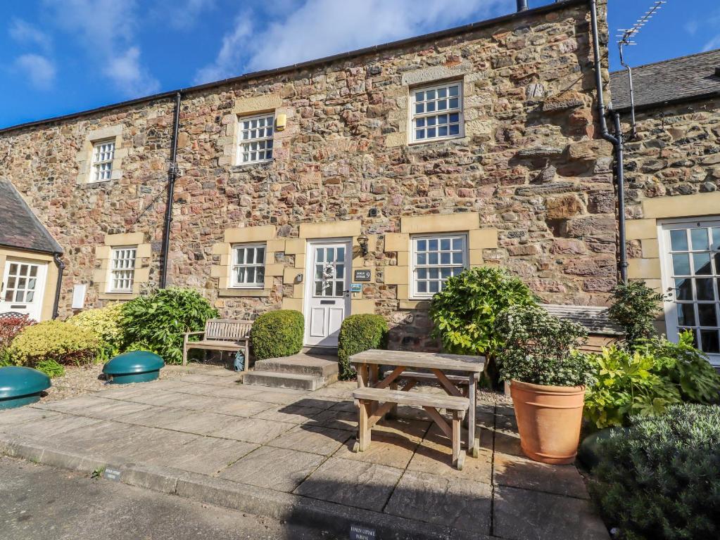 a stone building with two benches in front of it at No9 Budle Sands in Bamburgh