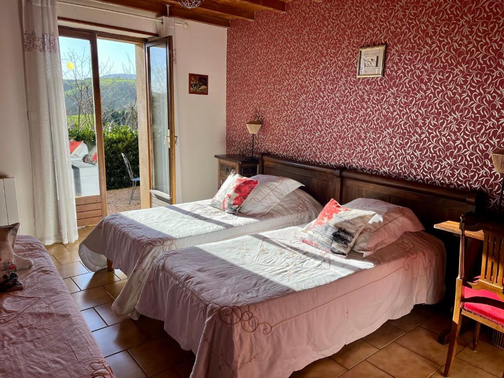 a bedroom with two beds and a window at Gîte LES GOUTTES 2 chambres 2 SDB in Courzieu