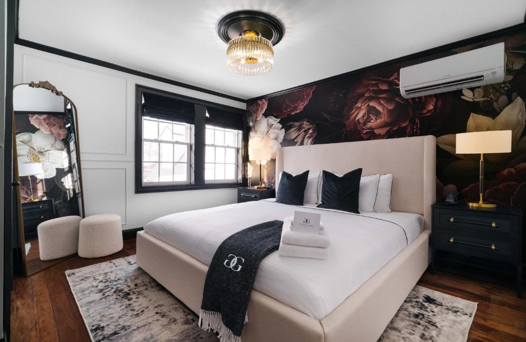 a bedroom with a large white bed with a painting on the wall at Garden Gables in Lenox