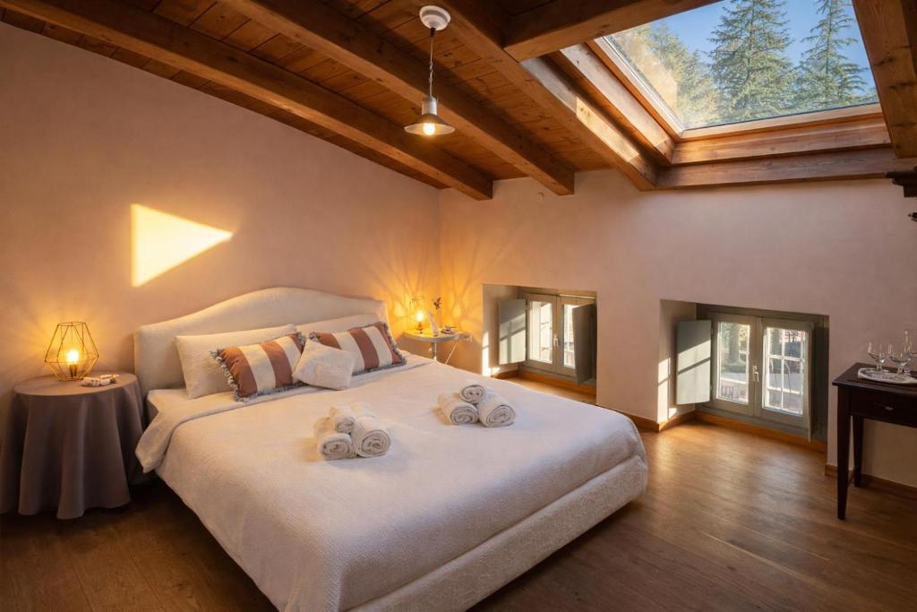 ein Schlafzimmer mit einem großen weißen Bett und einem Dachfenster in der Unterkunft Greif Boutique Juna in Aurisina