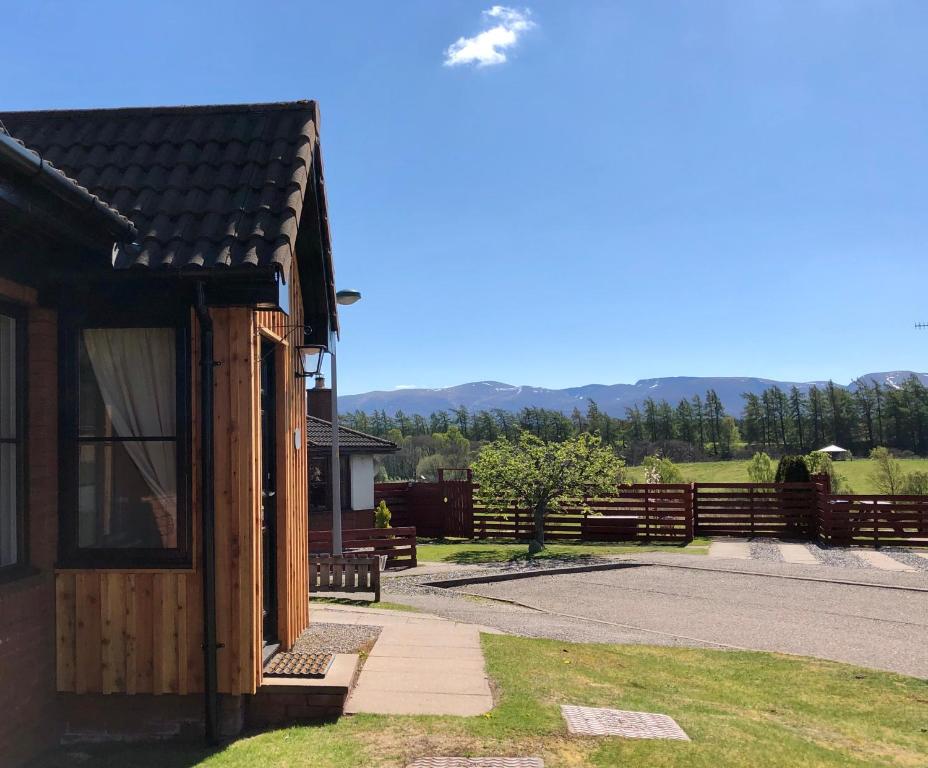 a cabin with a view of the mountains in the background at Blaeberry Cottage in Aviemore