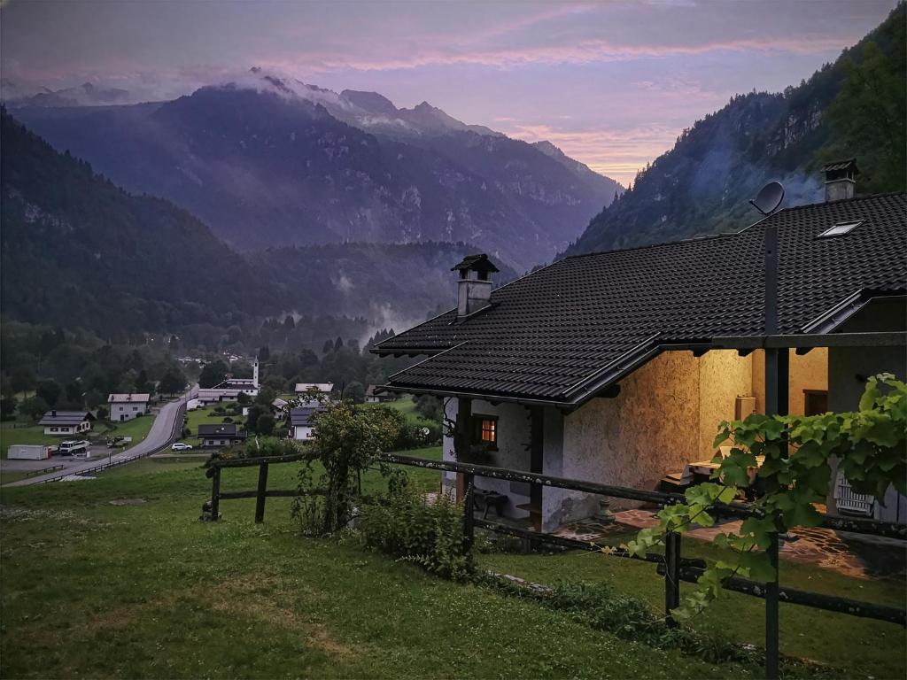 a house in a field with mountains in the background at Casa Davide Valdaone in Daone