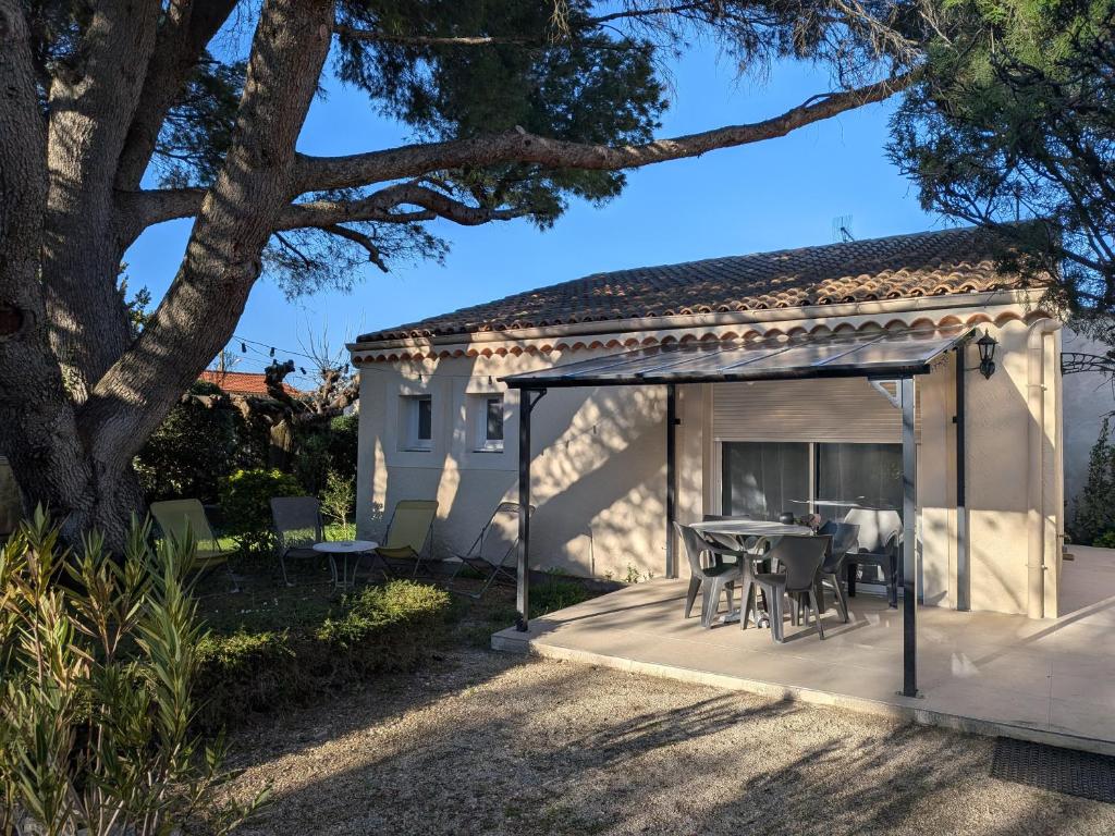 a pavilion with a table and chairs on a patio at À l'ombre du pin in Entraigues-sur-la-Sorgue