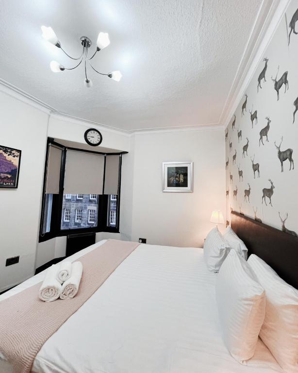 a bedroom with a large white bed with two towels at Old Town Castle Apartment in Edinburgh