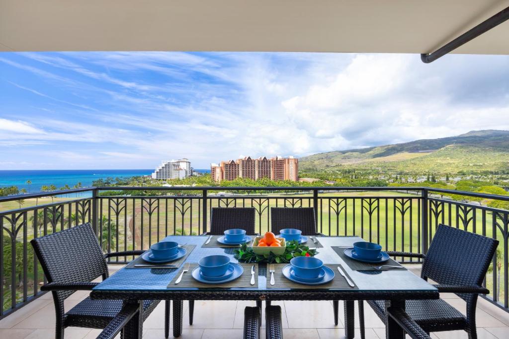 a table on a balcony with a view of the ocean at Ko Olina Beach Villas O1111 in Kapolei