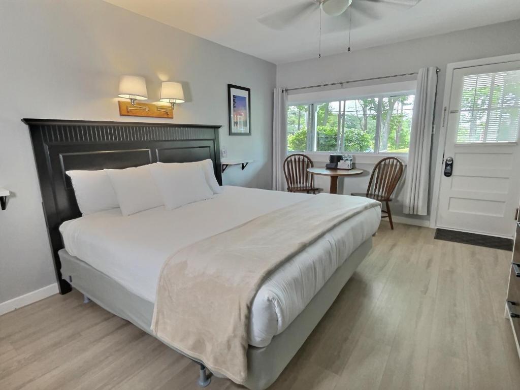 a bedroom with a large bed and a table at Kennebunkport Motor Lodge in Kennebunkport