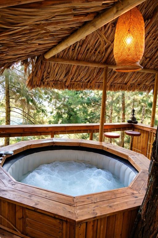 an outdoor hot tub in a wooden building with a roof at OMGHAT Glamping in El Peñol