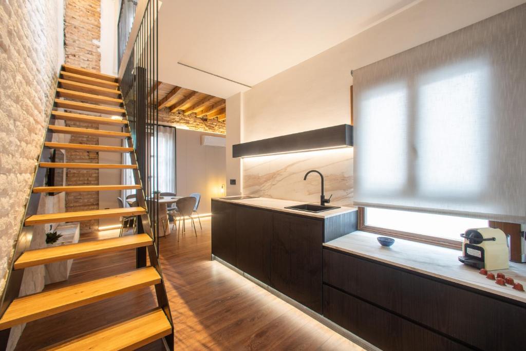 a staircase leading up to a kitchen with a sink and a window at Patio Nazarí Suites in Granada