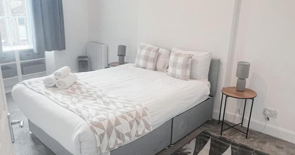 a bedroom with a bed with white sheets and pillows at New Town Residence in Edinburgh