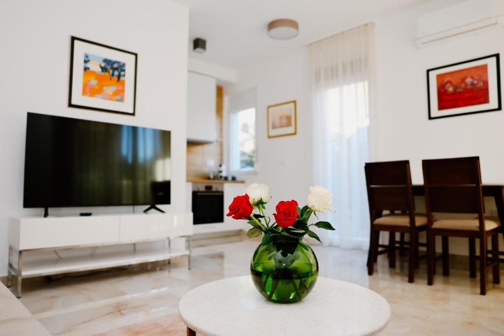 a living room with a vase of flowers on a table at Bellavista Garden in Baošići