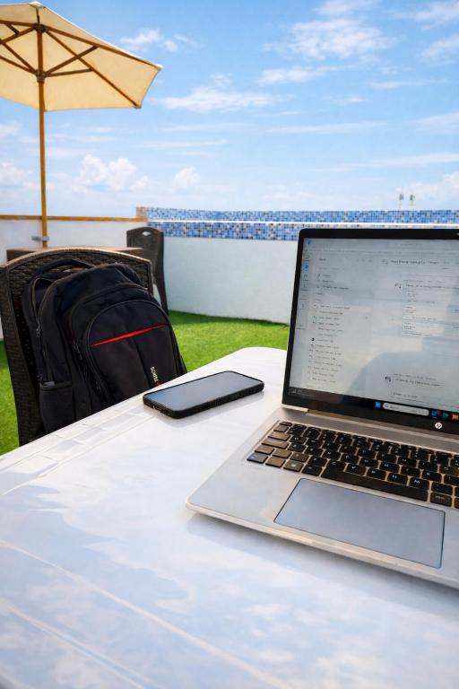 a laptop computer sitting on a table with an umbrella at Kaihalulu Beach Room - Punta Hermosa in Punta Hermosa