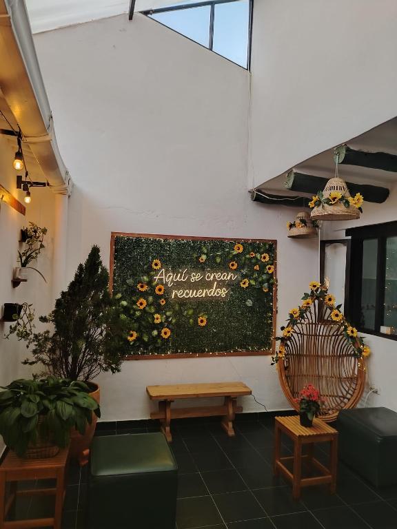 a sign on a wall with a bench and flowers at Villa Girasol in Villa de Leyva