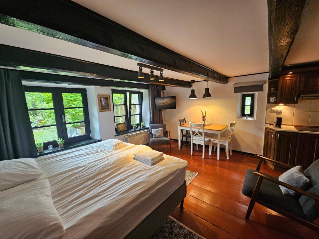 a bedroom with a large bed and a dining room at Ojcówek in Grzymek