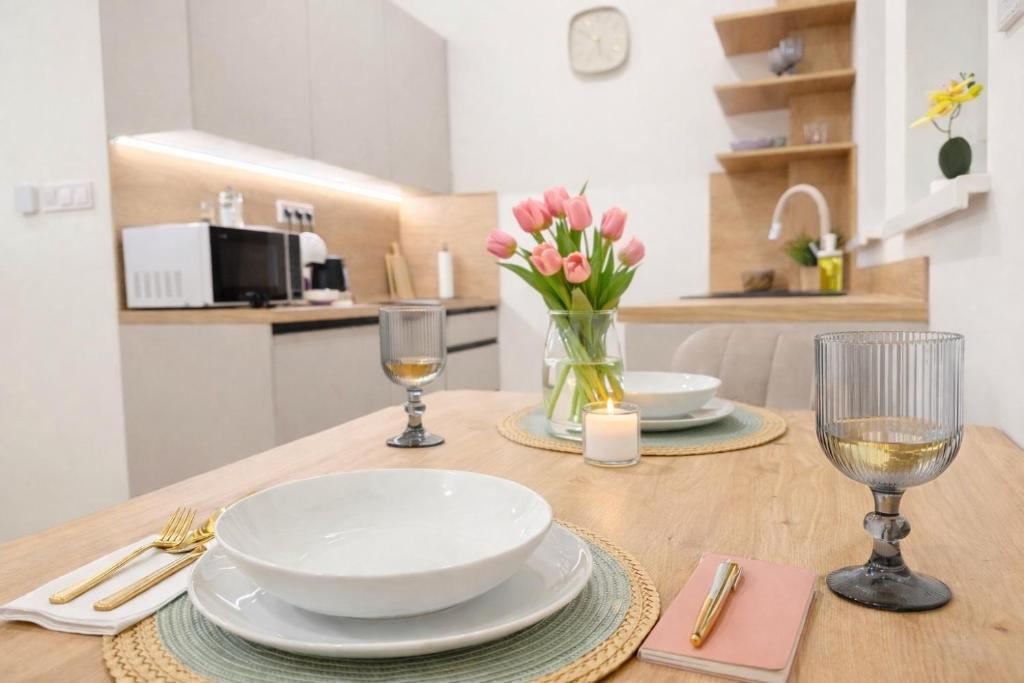 a table with plates and glasses and a vase of flowers at Station APA s parkovaním in Michalovce