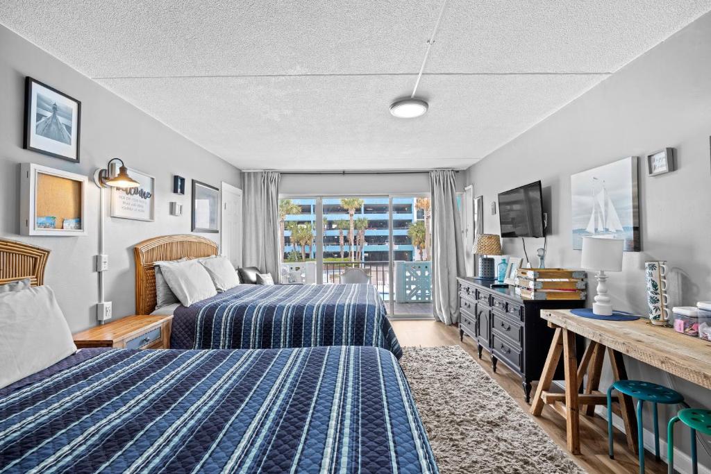 a hotel room with two beds and a window at Pool Front & Across from Beach in Myrtle Beach