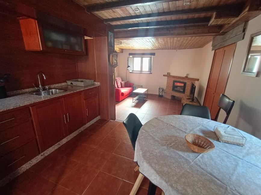 a kitchen with a table and chairs and a living room at La casa de Somiedo in Pola de Somiedo