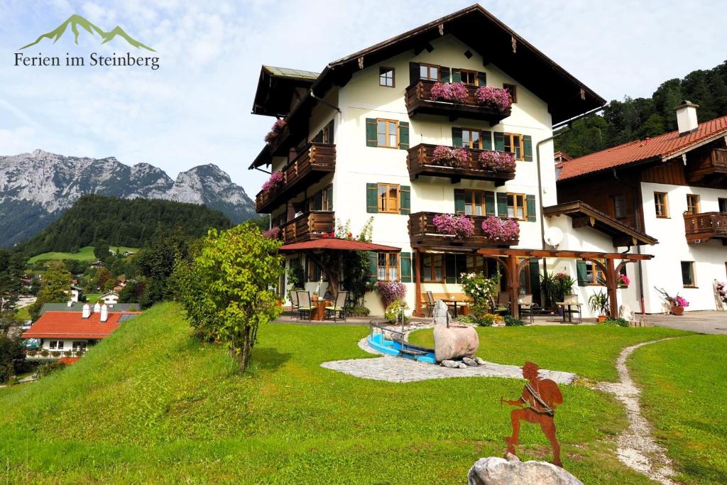a large building on a hill with a house at Ferien im Steinberg in Ramsau