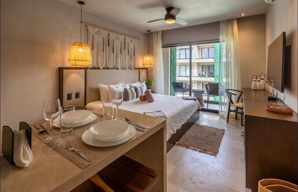 a bedroom with a bed and a table with plates on it at Bakal Luxury condos in Tulum