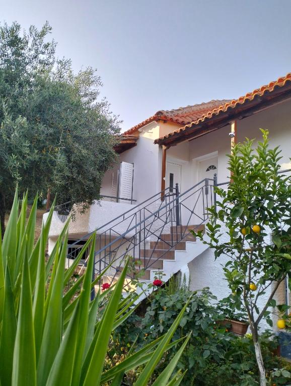a house with a staircase in front of it at Thea's Apartment in Vrachos