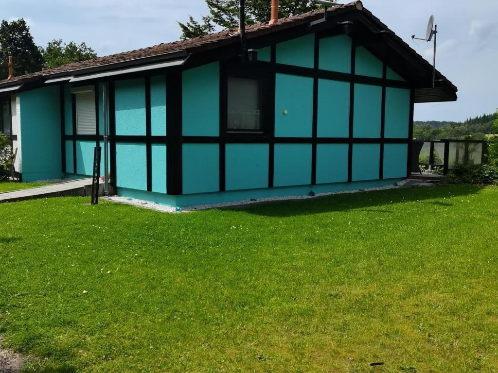 a blue house with a green lawn in front of it at Holiday Home in Germany with Scenic Nature in Berneburg