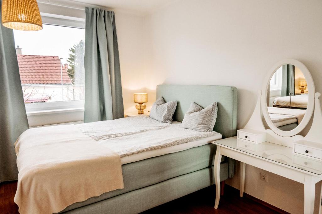 a bedroom with a bed with a mirror and a table at Wohnen bei frau tinz - Apartment - Bahnhof- und Zentrumsnähe in Neunkirchen