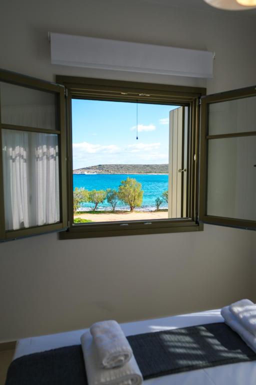 a bedroom with a window with a view of the ocean at Villa Selina 1 - Etheras Properties in Kythira