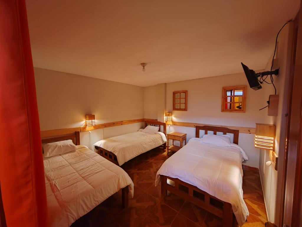 a room with two beds and two lights on at Alma Andina Lodge in Huaraz