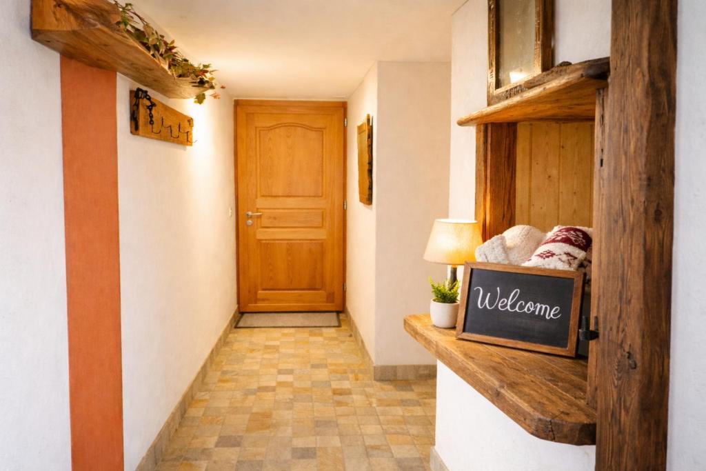 a hallway with aoyer with a door and a wooden shelf at Maison d'Hortense - Chalet le Renard in Hérémence