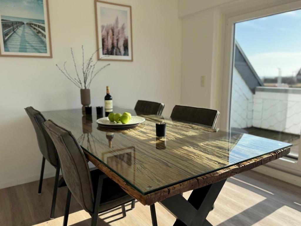a dining room with a table with chairs and a glass tableablish at Küstenbude Ostseestübchen in Grömitz