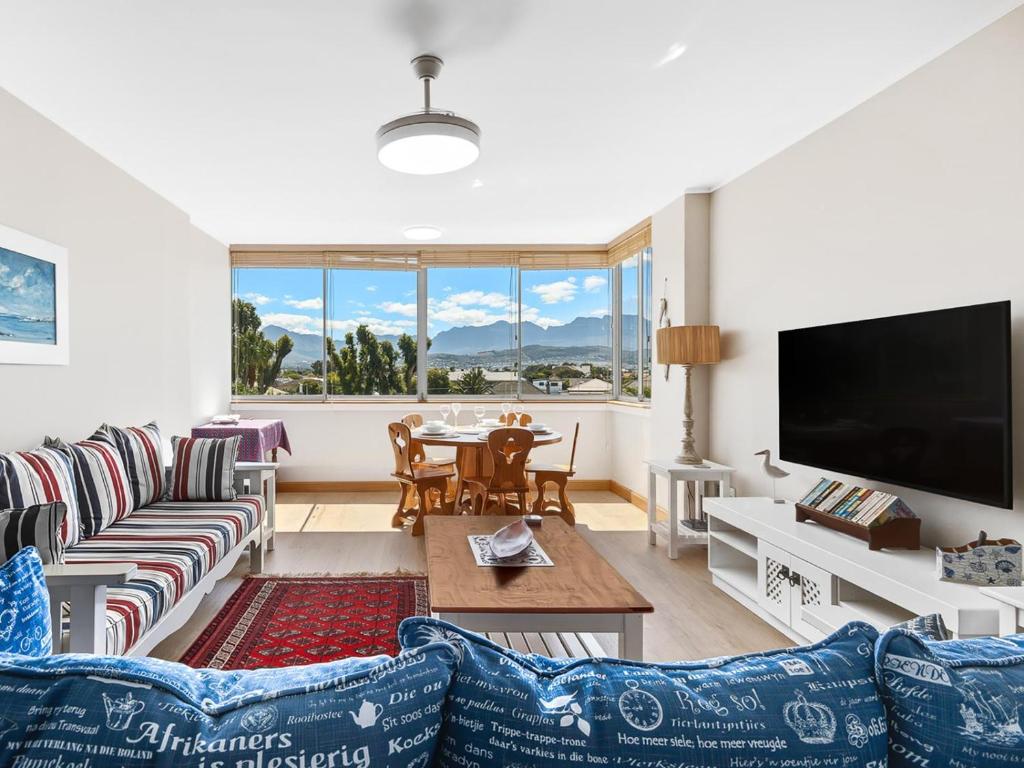 a living room with a couch and a tv at Coastal Condo Strand in Strand