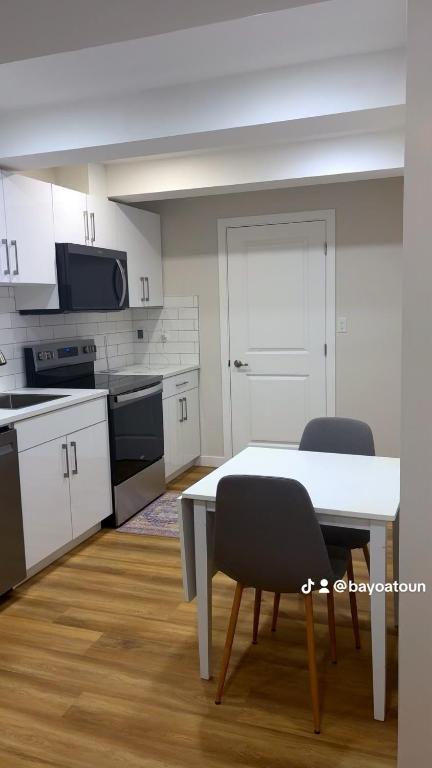 a kitchen with a table and chairs in a room at Cozy Urban Hideout in Saskatoon