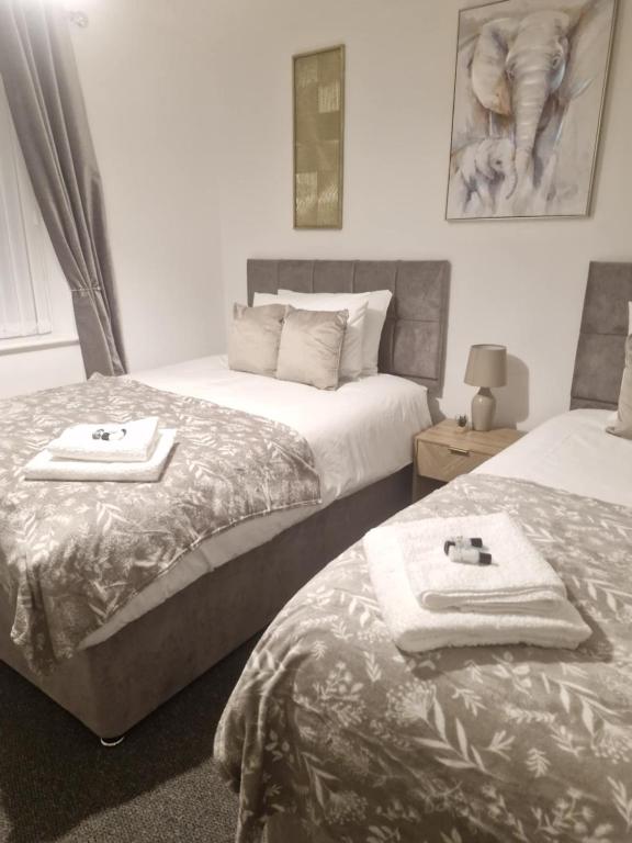 a bedroom with two beds with towels on them at Leasowe House in Bidston