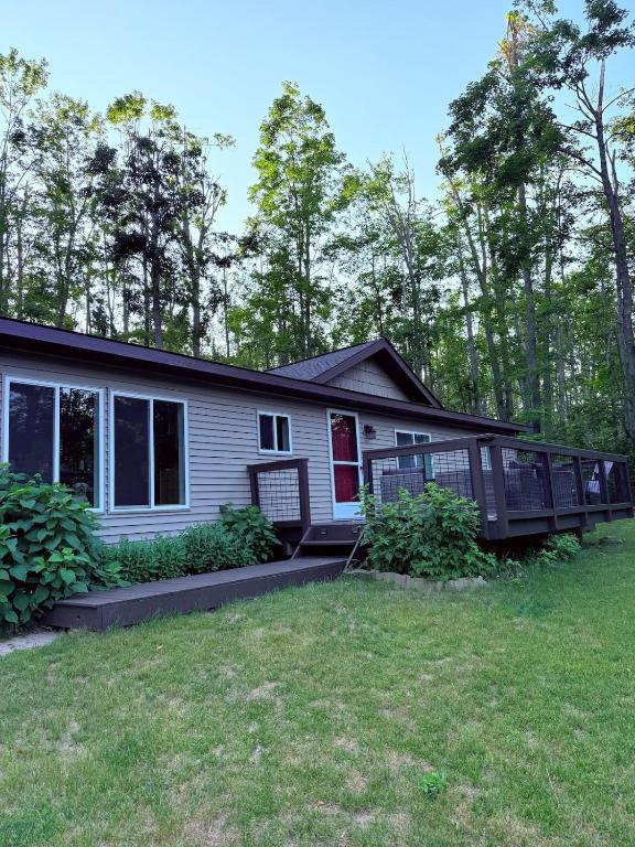 a house with a porch and a yard at Sugar Maple Getaway in Gaylord