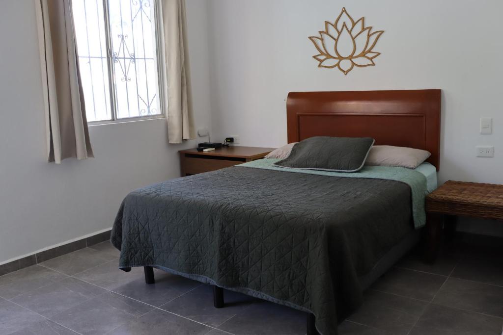 a bedroom with a bed and a table and a window at CASA JARDIN in Cancún
