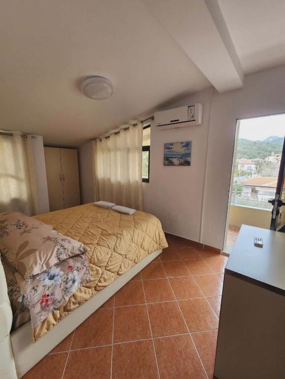 a bedroom with a bed and a large window at Apartment 4 by Villa Ceni in Elbasan
