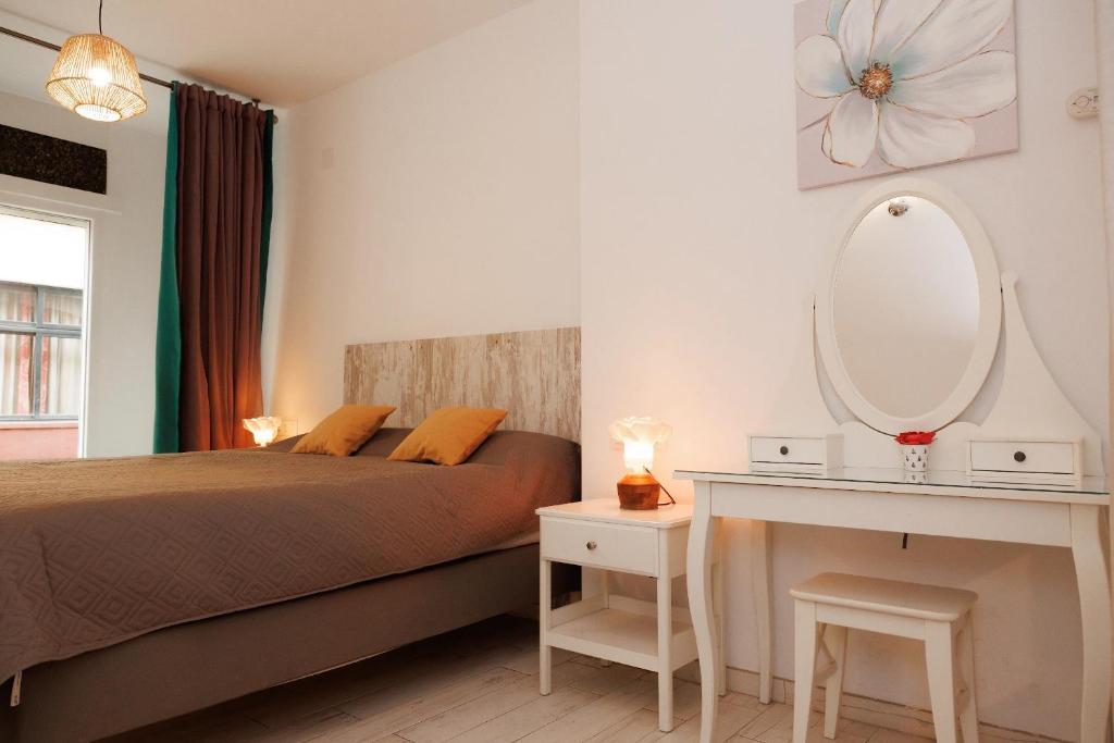 a bedroom with a bed and a mirror and a table at Loft Valentia Ifach Calpe in Calpe